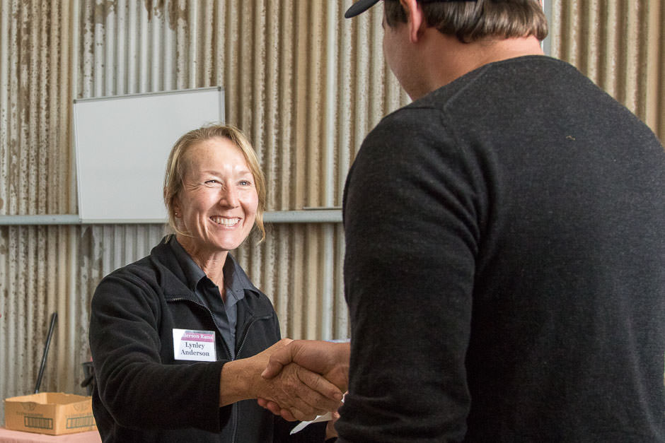 photo of smiling woman shaking hand of buyer